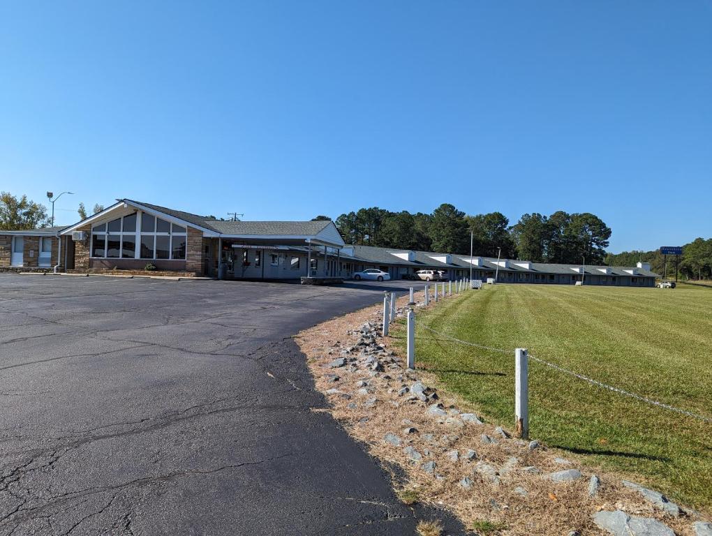 a building with a road in front of a field at TRAVELER'S INN in Smithfield