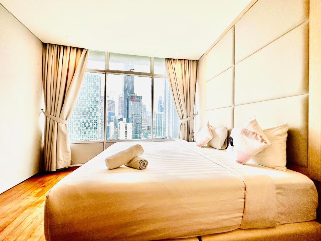 een slaapkamer met een groot bed en een groot raam bij Vortex Suites Near Klcc-365 in Kuala Lumpur
