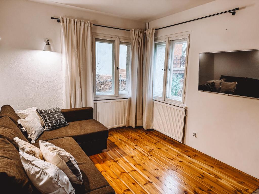 a living room with a couch and two windows at Domek w Karpaczu in Karpacz