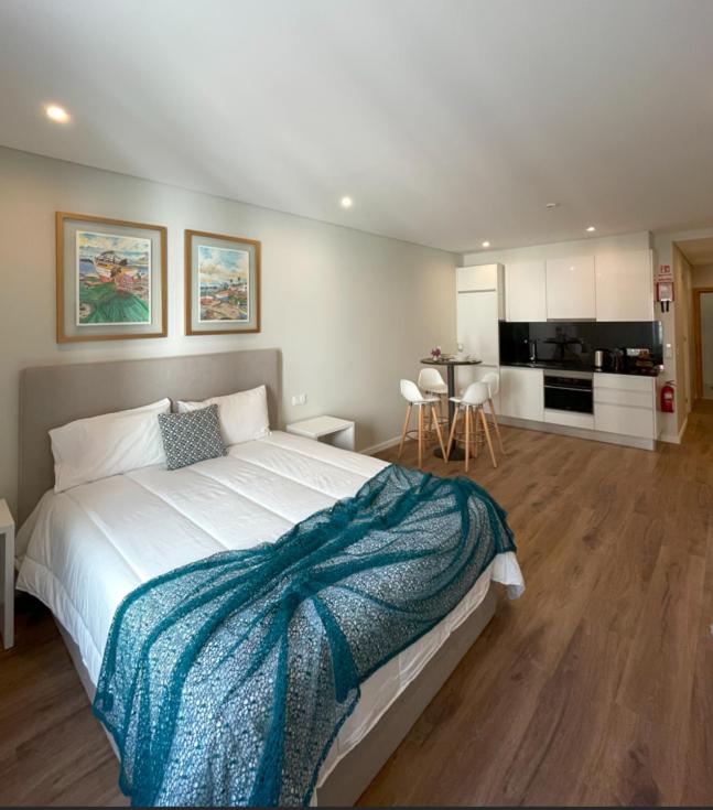 a bedroom with a large bed and a kitchen at Vicente´s LOB ( Lobos Ocean Breeze) in Câmara de Lobos