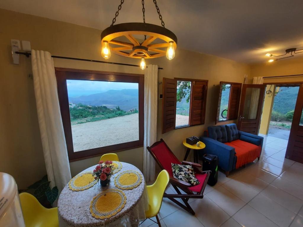 a living room with a table and chairs and a couch at Chalé na Serra in Mulungu