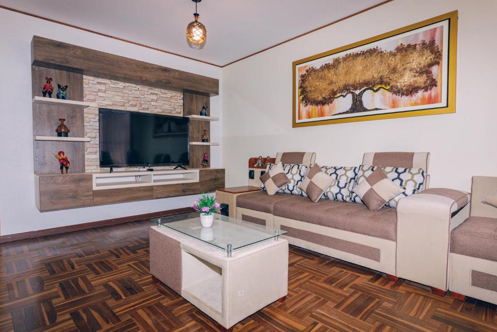 - un salon avec un canapé et une télévision dans l'établissement PAKARINA HOUSE, à Cusco