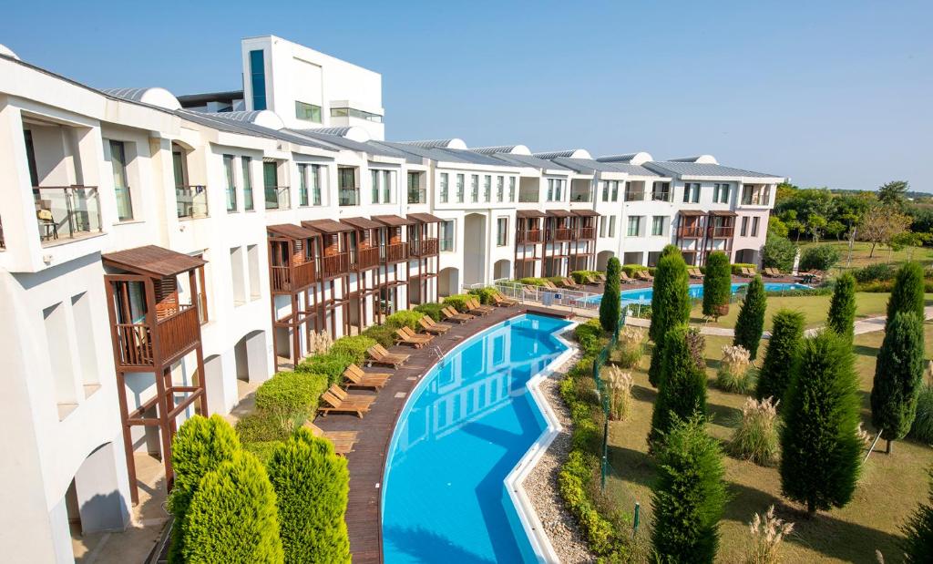 Denizyaka的住宿－Lykia World Links Golf Antalya，公寓大楼设有游泳池和树木