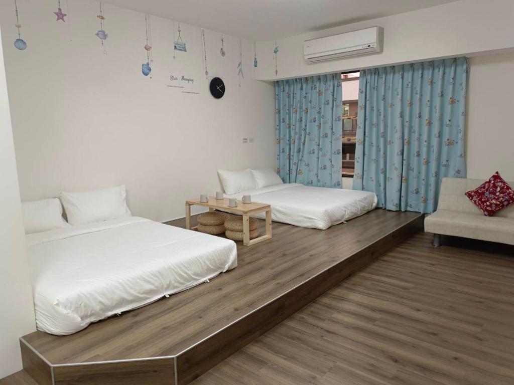 um quarto com duas camas e um sofá em 星之芳庭 潮州民宿 親子寵物友善 em Chaozhou