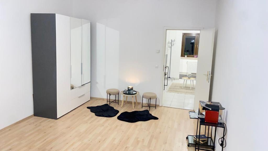 Camera bianca con 2 sedie e uno specchio di Charming Apartment a Vienna
