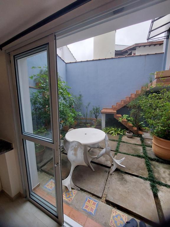 une table blanche et une chaise assise sur une terrasse dans l'établissement Espaço acolhedor com transporte público de fácil acesso, à São Paulo