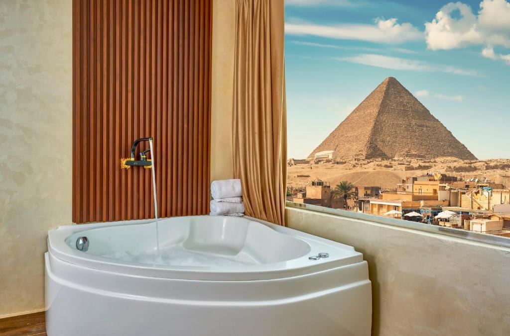 a bath tub in a room with the pyramids at Cleopatra Tower Pyramids View in Cairo