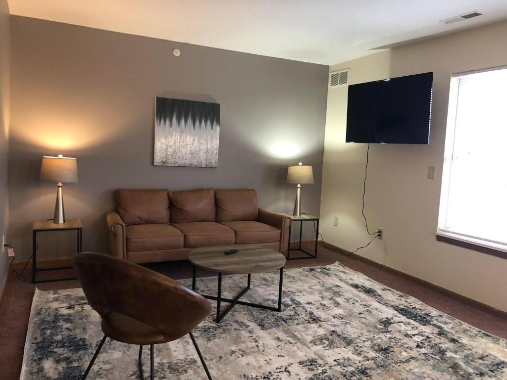 a living room with a couch and a flat screen tv at 2 bedroom apartment RivianISU in Bloomington