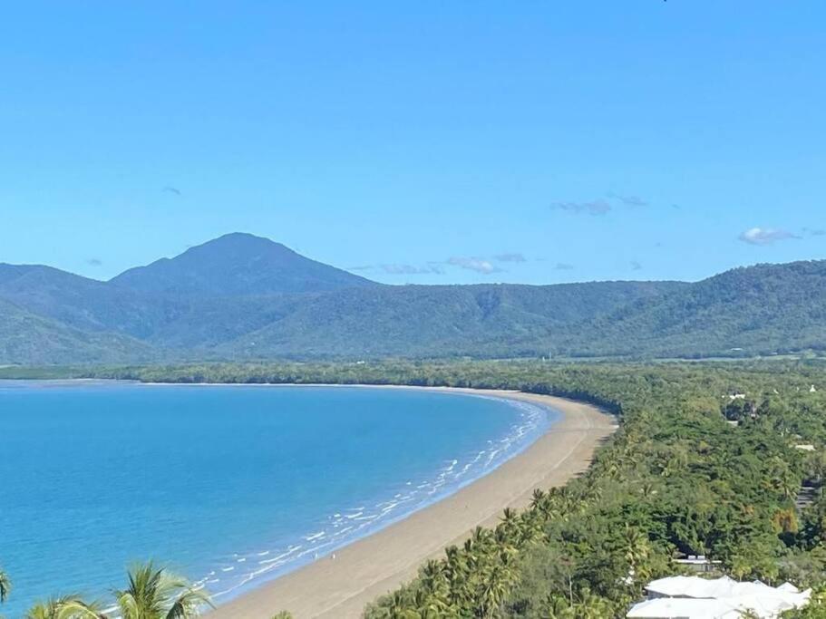 uitzicht op een strand met bergen op de achtergrond bij 1 Min walk from, Beach and Town - Beachcomber in Port Douglas