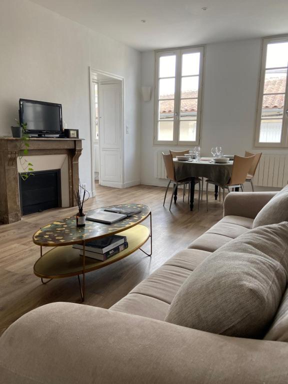 un salon avec un canapé et une table dans l'établissement Magnifique appartement - Hyper centre Vieux Cognac, à Cognac