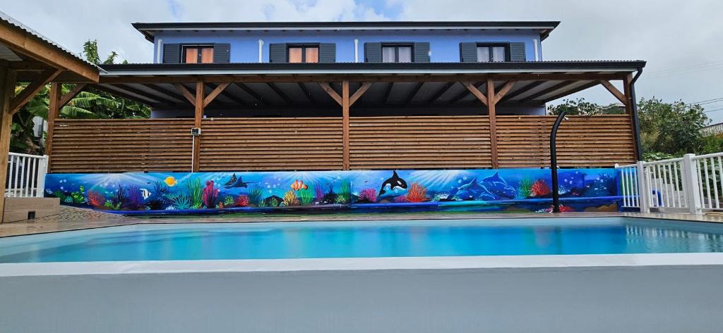 una casa con un murale di una piscina di LES GITES D'ANGELE a Vieux-Habitants
