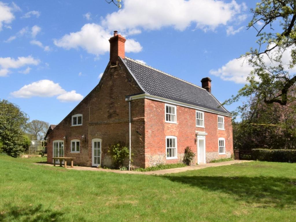 a large red brick house on a green field at 5 Bed in Wroxham 56103 in Hoveton