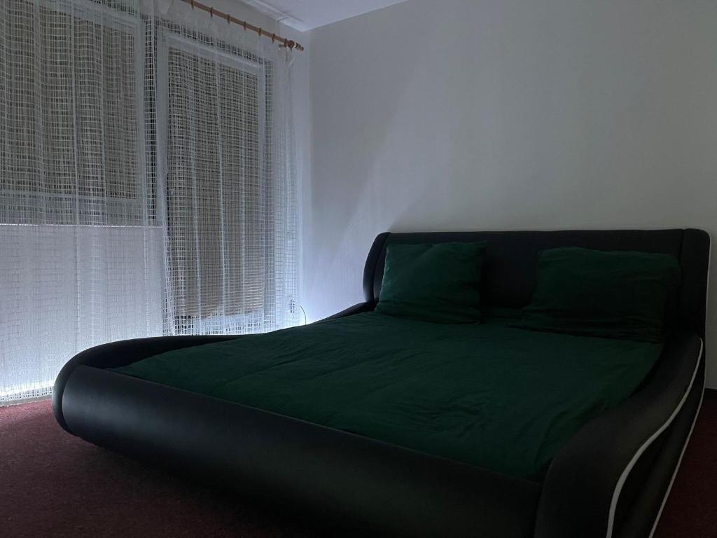 una cama sentada en una habitación junto a una ventana en Soukroma ložnice s terasou a pracovnou, en Praga