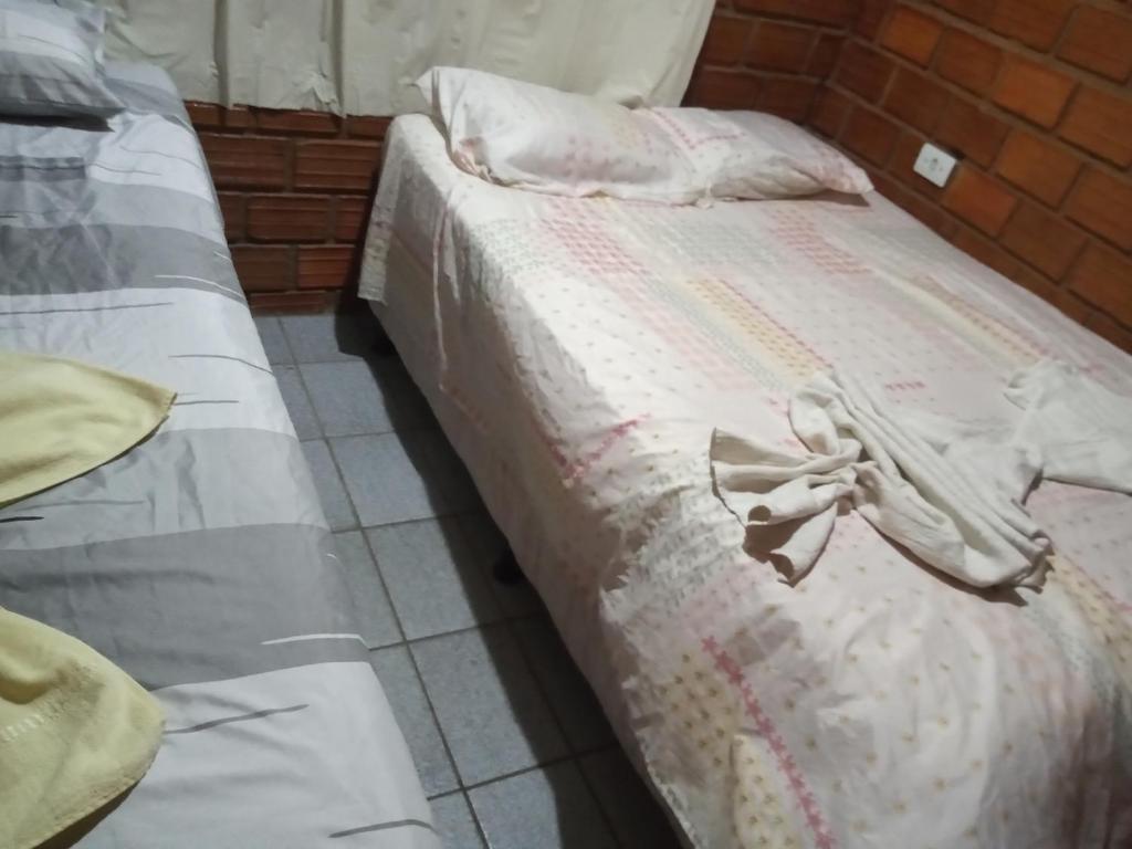 uma cama com lençóis brancos e um laço em Casa de Porto de Galinhas 137 em Porto de Galinhas