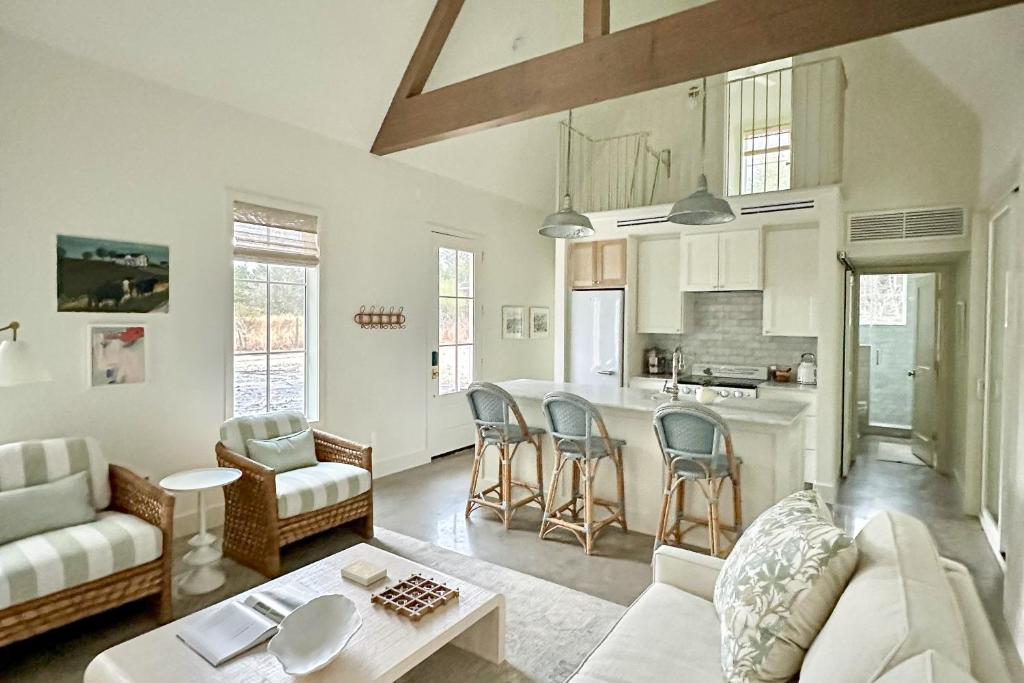a living room with a couch a table and a kitchen at Off-Grid & Elegant Farmhouse Near Somerville Lake in Brenham