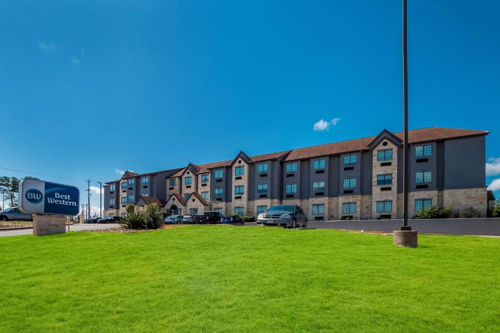 a building with a green lawn in front of it at Best Western SeaWorld San Antonio in San Antonio