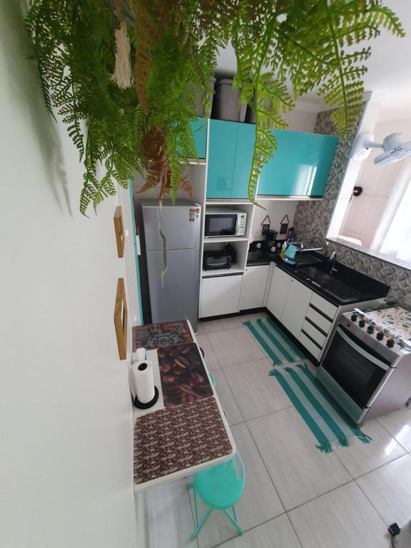 a kitchen with blue and white cabinets and a table at Bertioga Praia do SESC - Apartamento de 2 quartos in Bertioga