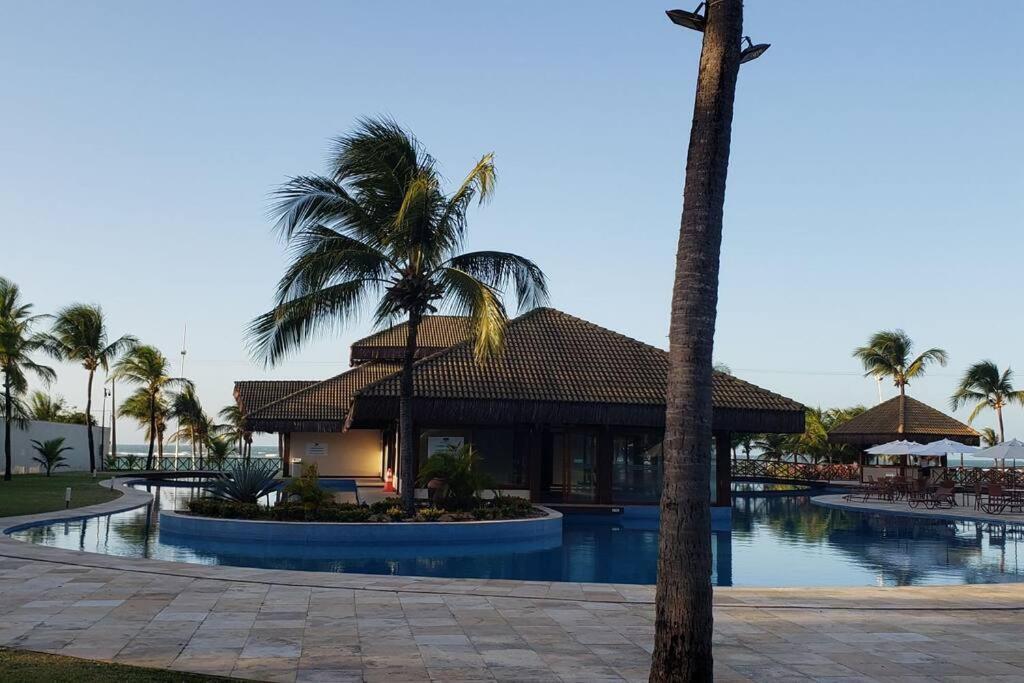 un complexe avec une piscine et des palmiers dans l'établissement Flecheiras Eco Residence Un302, à Flecheiras