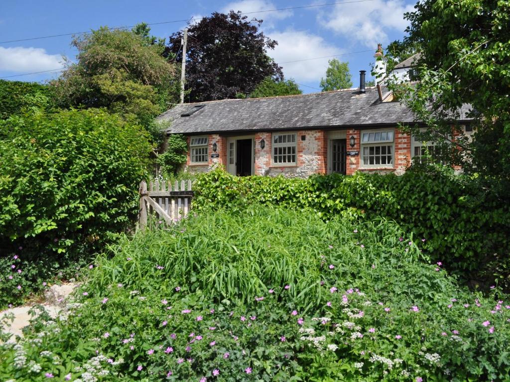 uma antiga casa de pedra no meio de um jardim em 2 bed property in Axminster BLOLO em Axminster