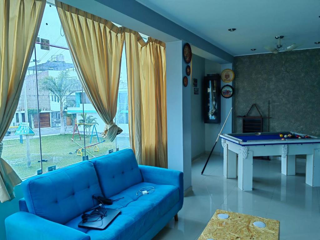 ein Wohnzimmer mit einem blauen Sofa und einem Billardtisch in der Unterkunft Gardella House, Casa - Hotel in Ica