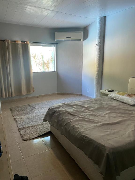 a bedroom with a large bed and a window at Casa Residencial Tarumã in Manaus