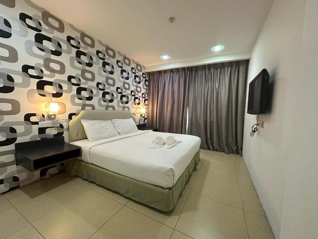 a bedroom with a large bed and a wall at Alia Express Hotel Twelve a12 Kuantan in Kuantan