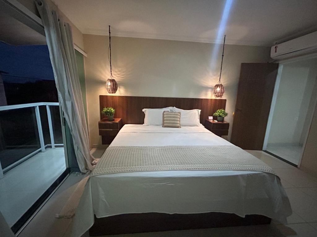um quarto com uma cama grande e uma varanda em Casa Praia São Jose Maragogi 4 em São José da Coroa Grande