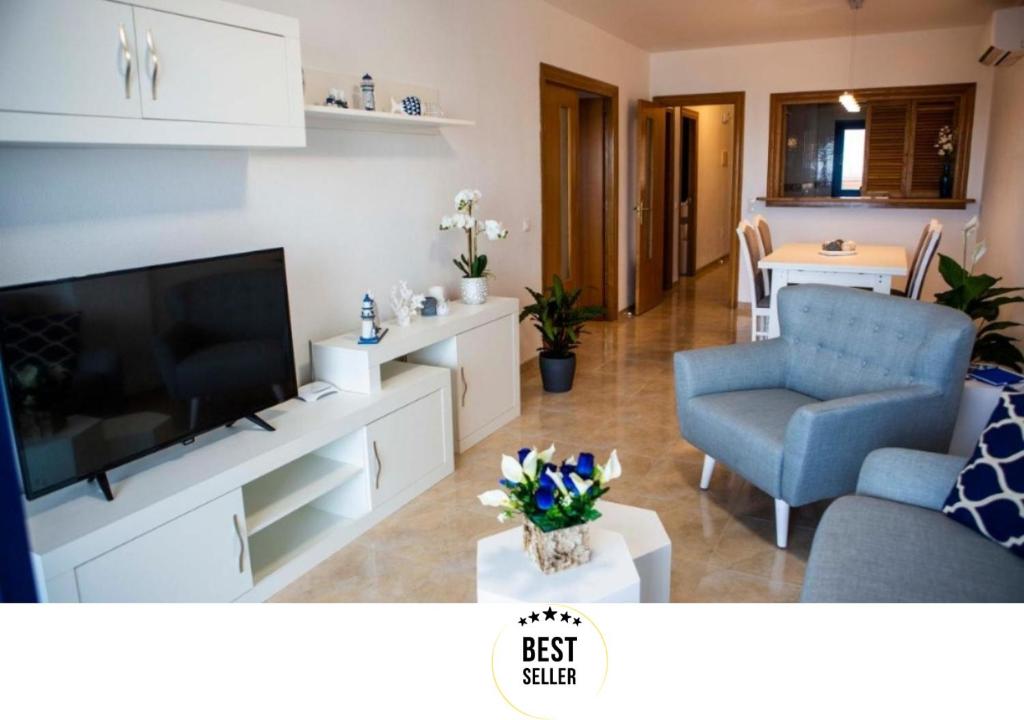 a living room with a television and a blue chair at Apartment las sirenas WiFi 100 Mb in Roquetas de Mar