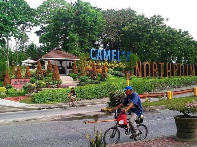 a man riding a bike in front of a park at 1608 Three Bedrooms With 1 free parking, swimming pool WiFi and Netflix at Northpoint Camella Condominium Bajada Davao City in Davao City