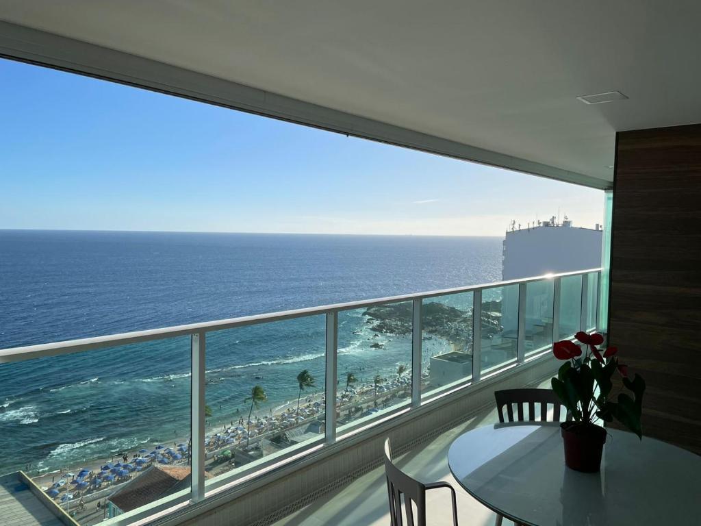 balcón con mesa y vistas al océano en Apartamento na Barra alto padrão com vista mar, en Salvador