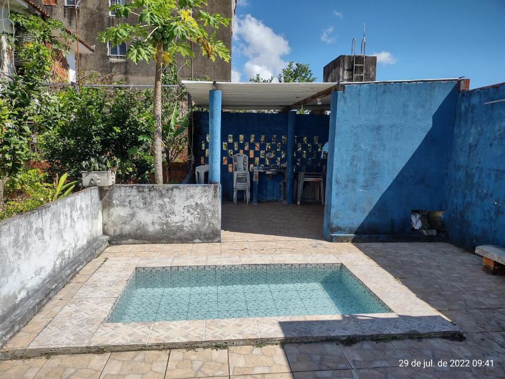 een zwembad met water op een binnenplaats met een tafel bij Casa Temporada Prainha - Aquiraz in Aquiraz