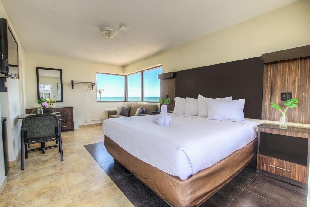 una camera d'albergo con un grande letto e una scrivania di La Bella Oceanfront Inn - Daytona a Daytona Beach