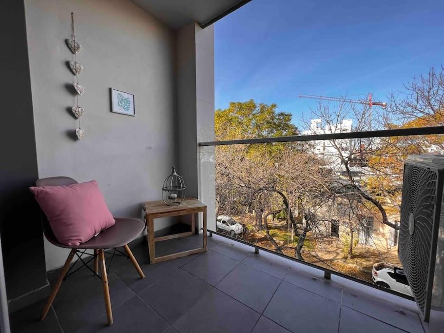 um quarto com uma cadeira e uma grande janela em Elegante apto en corazón Pocitos em Montevidéu
