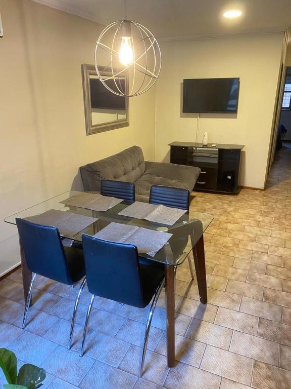un salon avec une table et des chaises bleues dans l'établissement Departamento -Ambrosio- a 100mts de Plaza España, Pleno Nueva Cordoba, para 4 personas, By Apartcba, à Córdoba