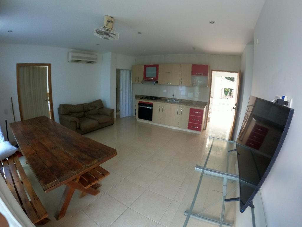 a living room with a table and a kitchen at Casa zumar in Coveñas