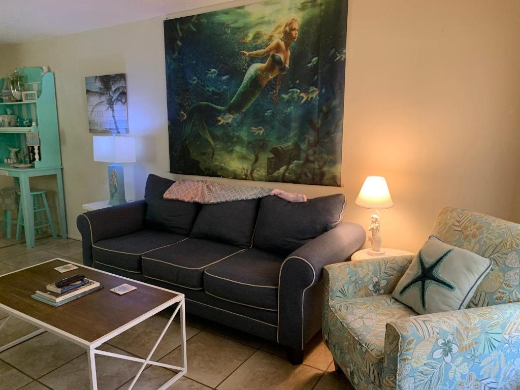 uma sala de estar com um sofá e uma pintura na parede em Professor Rousseau's Mermaid Lagoon em Crystal River