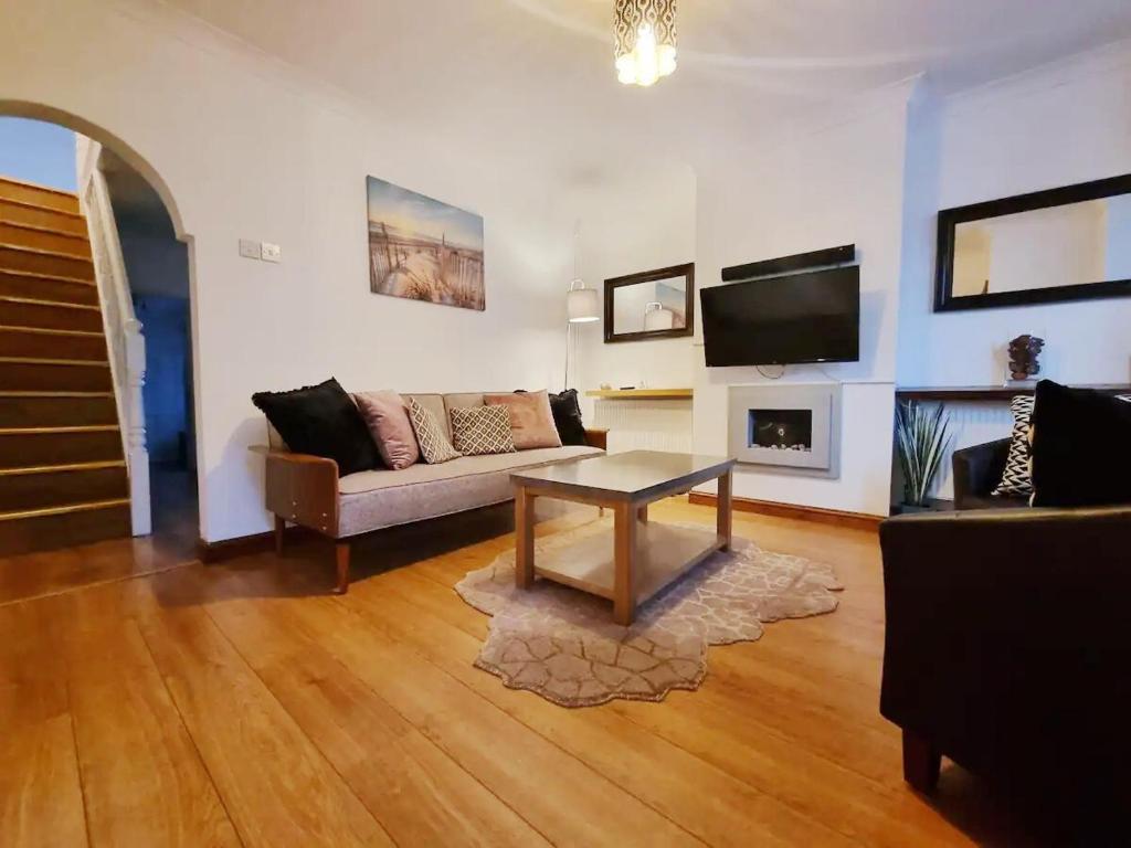 een woonkamer met een bank, een tafel en een tv bij Rochester Slopes - Free Street Parking in Strood
