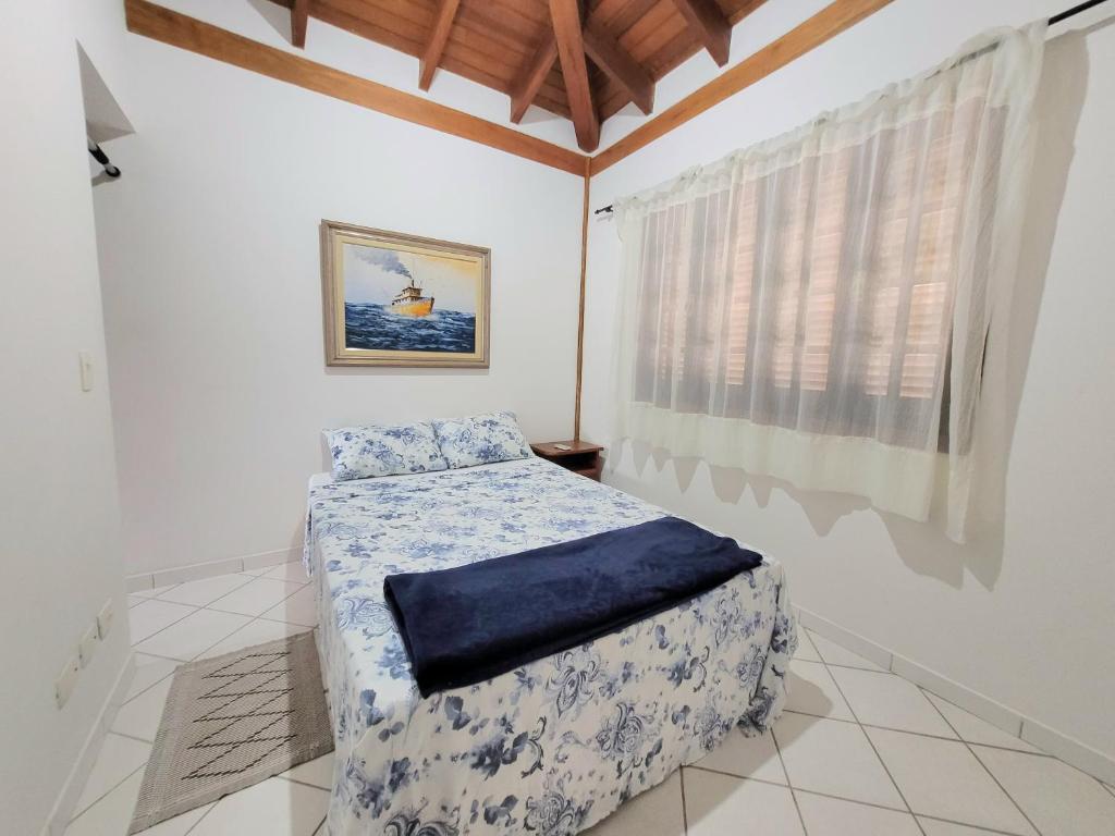 1 dormitorio con cama y ventana en Casa para temporada em Ilhabela, en Ilhabela