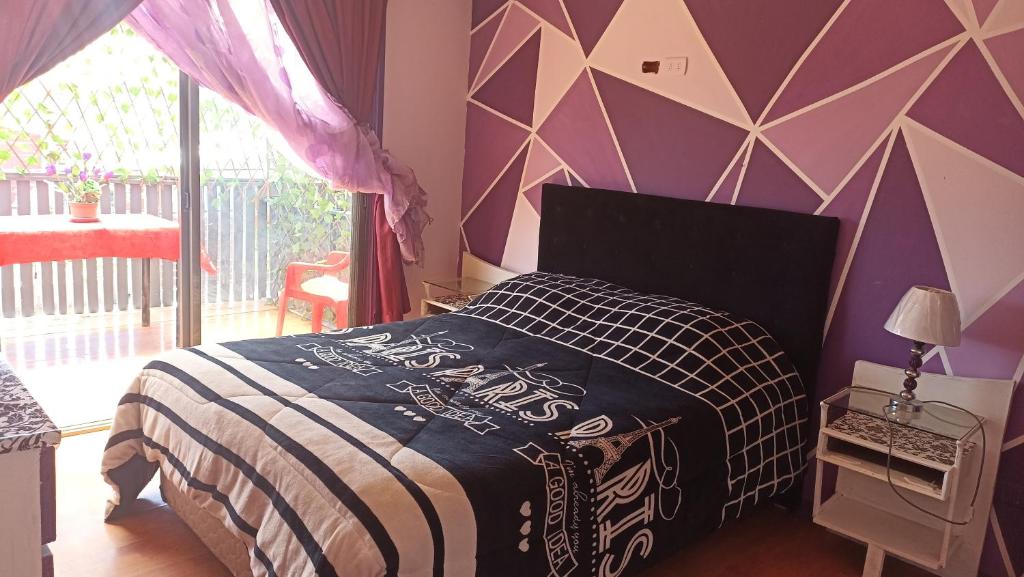 a bedroom with a bed and a purple wall at Hostal " Donde Alicia " in Cartagena