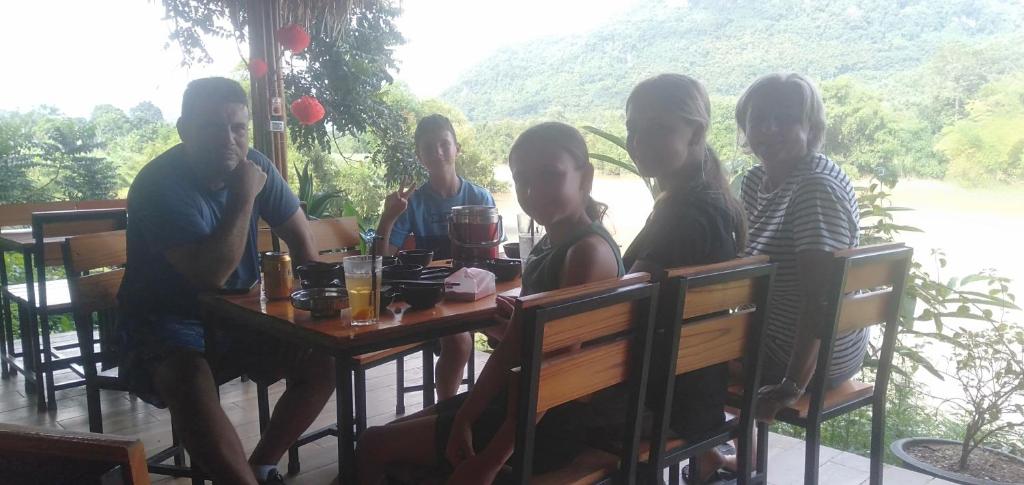 eine Gruppe von Menschen, die an einem Tisch sitzen in der Unterkunft Pù Luông Jungle Homestay in Pu Luong