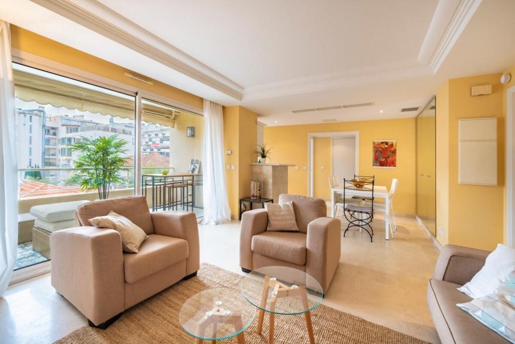 un salon avec un canapé, des chaises et une table dans l'établissement Cannes banane beau 2 pièces, à Cannes