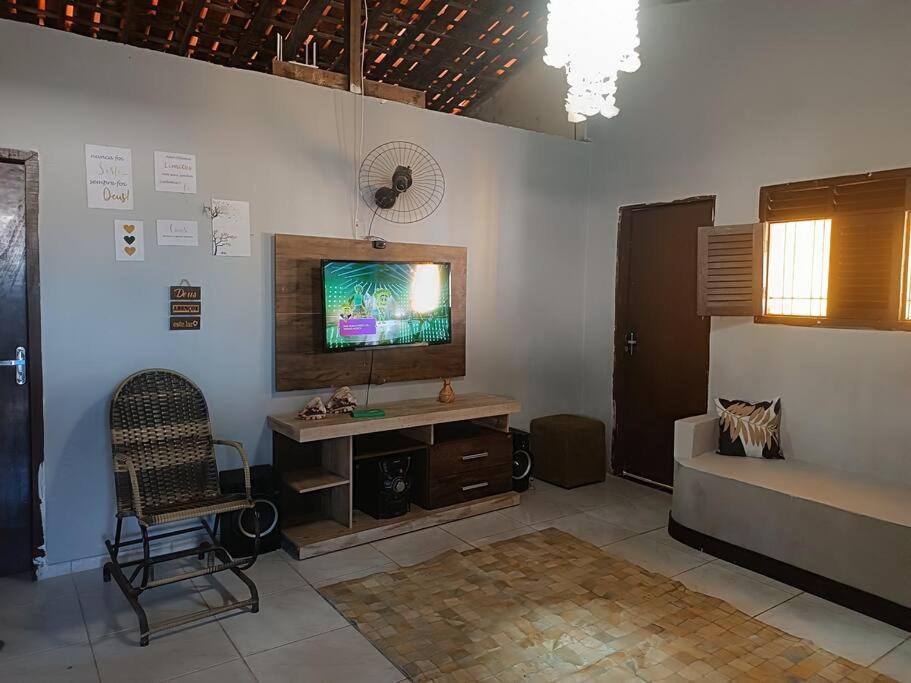 sala de estar con sofá y TV en la pared en Casa na praia Lucena para alugar por temporada, en Lucena