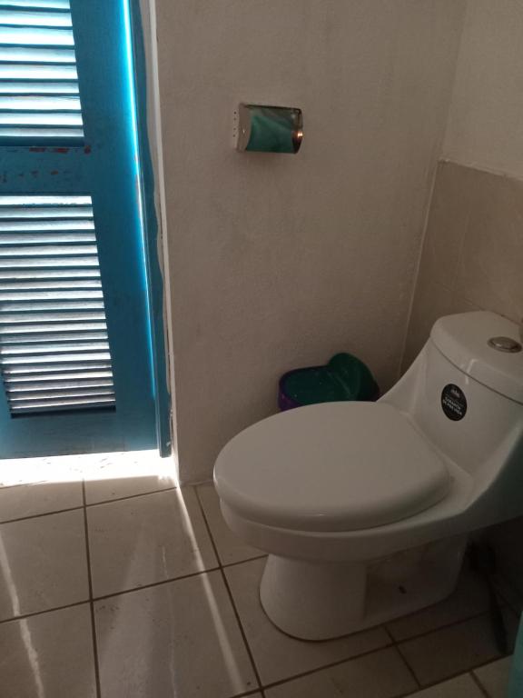 uma casa de banho com um WC branco e uma janela azul em Casa Via Gutierrez em San José