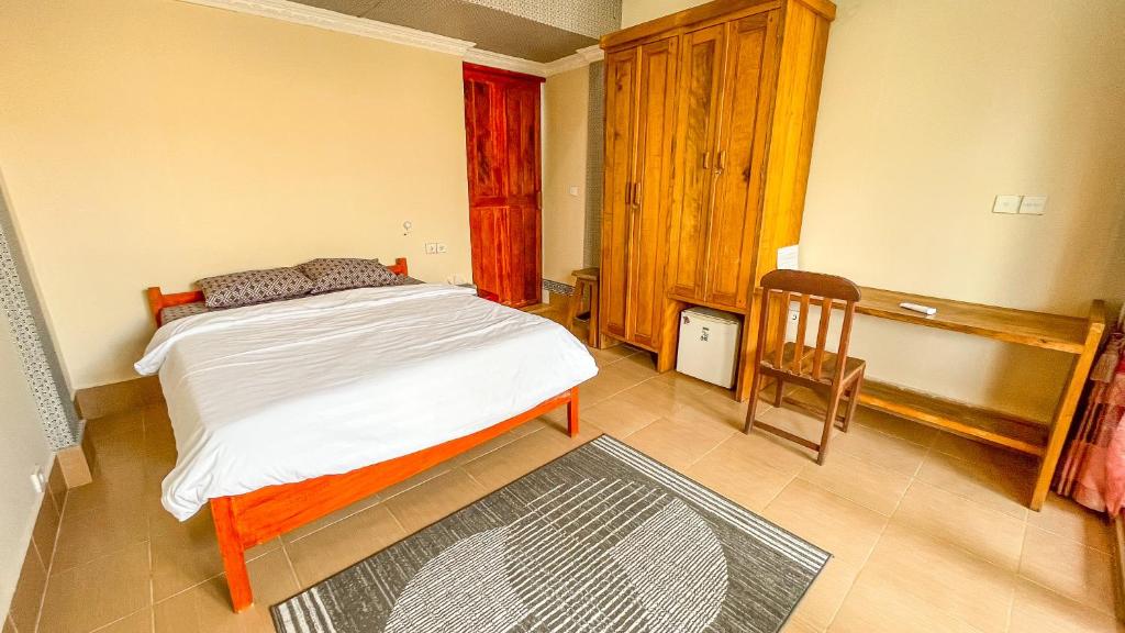 1 dormitorio con 1 cama y 1 silla en Sugesty Homestay, en Bumbang