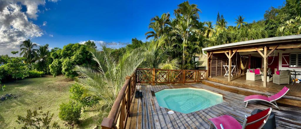 a house with a deck with a swimming pool at Kaz Manga Rose in Deshaies