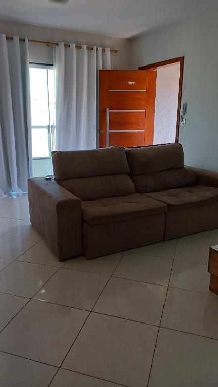 um sofá castanho sentado numa sala de estar em Apto em Marataízes-ES, 03 quartos e 02 banheiros em Marataizes