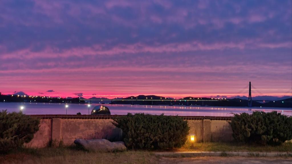 a sunset over a body of water at night at SM Resortel in Goheung