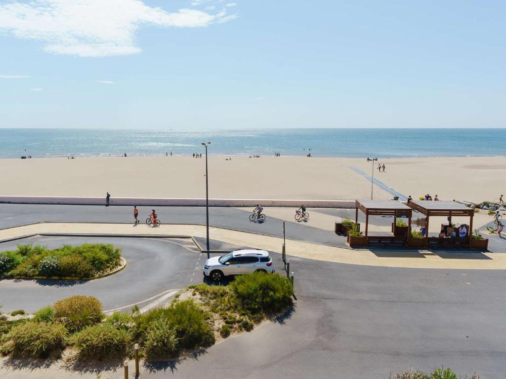 un'auto che guida lungo una strada vicino alla spiaggia di Appartement 4 pers avec WIFI, animaux admis, parking privé - FR-1-409-142 a Narbonne