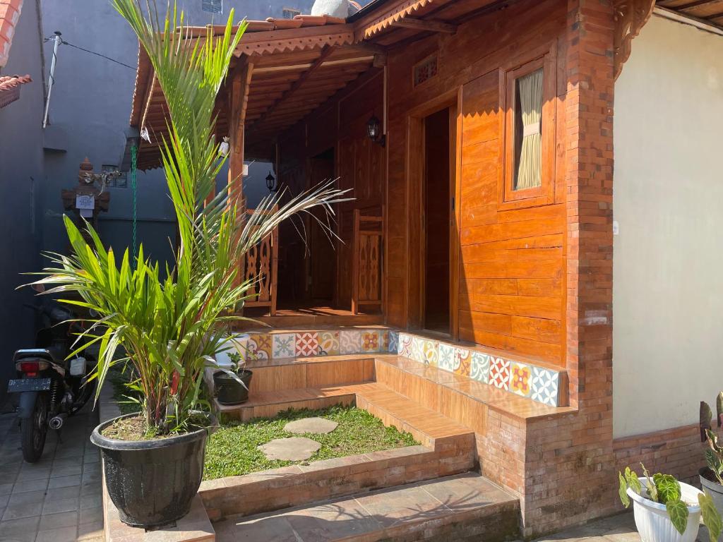 ein Haus mit einer Treppe, die zur Eingangstür führt in der Unterkunft Bharata Beach House in Keramas