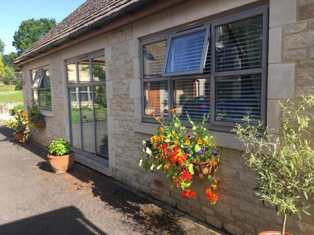 une maison avec des fleurs sur son côté dans l'établissement 2 Bed in Cheltenham 49336, à Southam